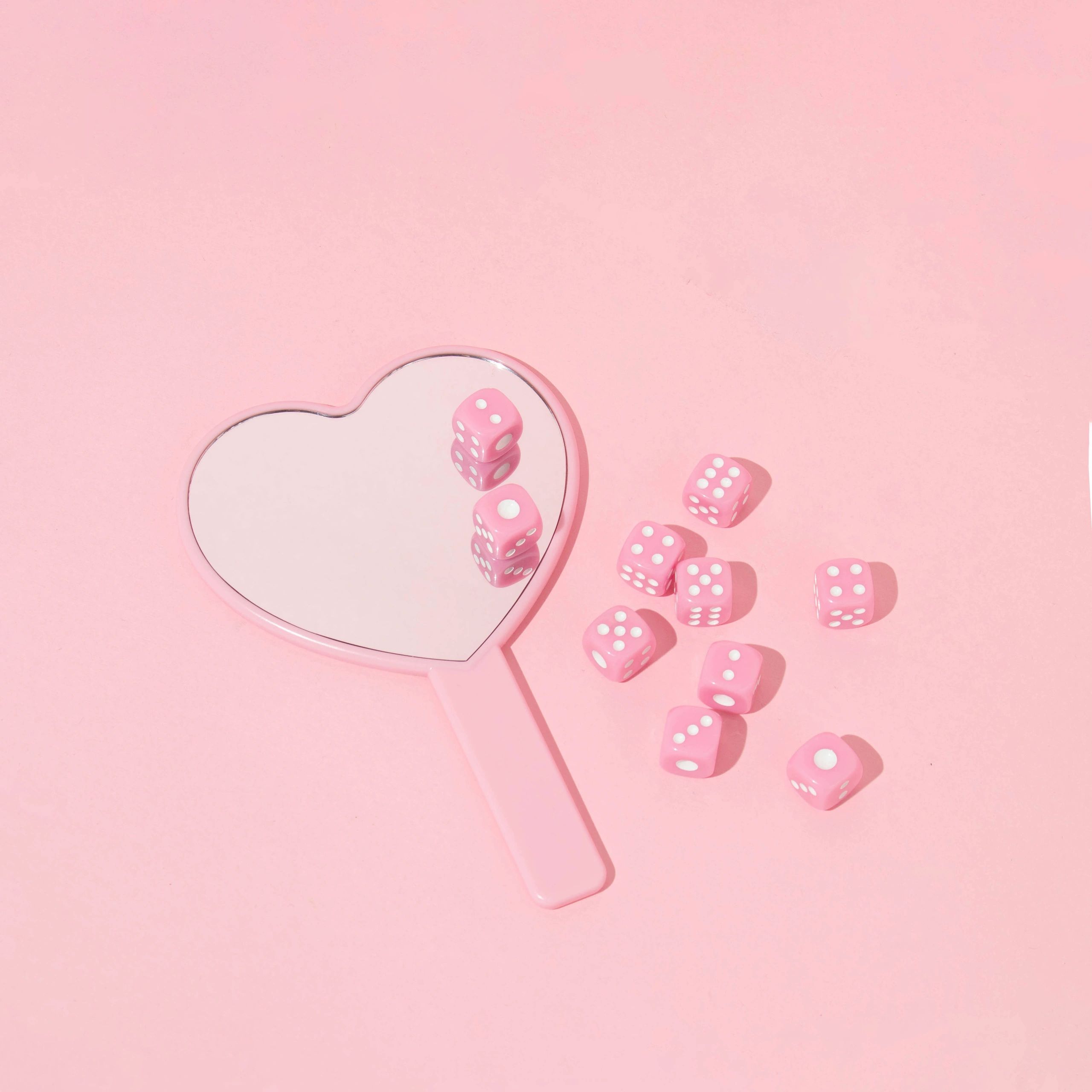 Colorful dice on a playful pink background